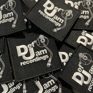 Puede incluir: Parches cuadrados negros con texto bordado blanco y un diseño de tocadiscos. Los parches muestran "Def Jam recordings" en una fuente audaz. El diseño incluye una ilustración detallada de un tocadiscos y sus componentes.