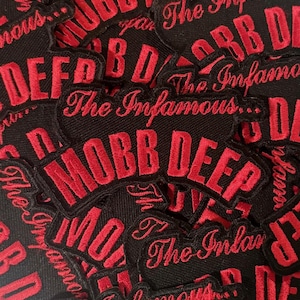 May include: A collection of black embroidered patches with the words "MOBB DEEP" in bold red letters. The phrase "The Infamous..." is also embroidered in red script. The patches are likely for clothing or accessories.