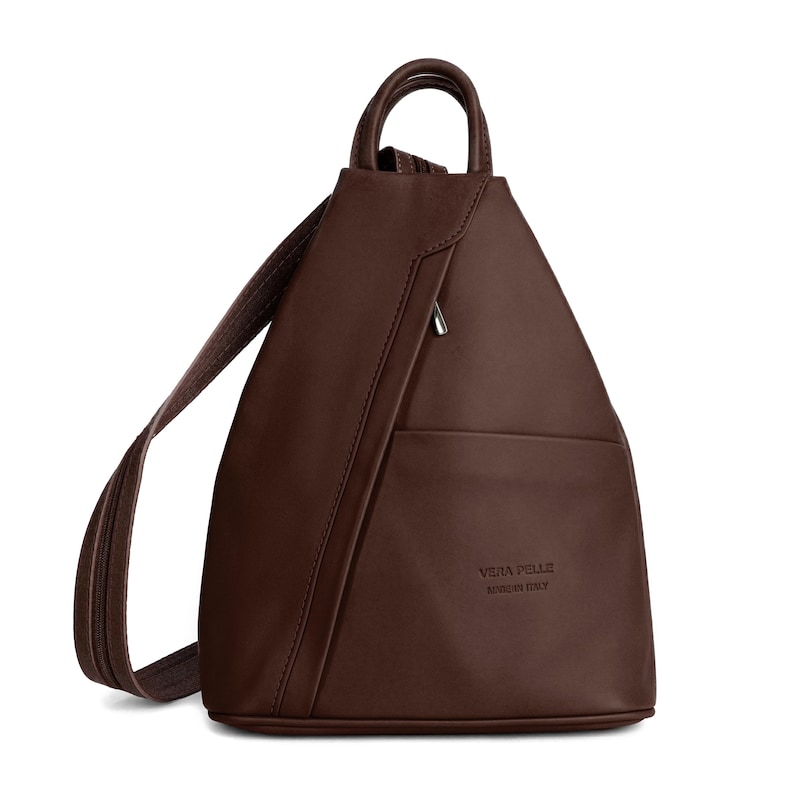 May include: A brown leather backpack with a single shoulder strap and a top handle. The bag has a triangular shape with a zippered pocket and a small pocket on the front. The words "VERA PELLE MADE IN ITALY" are embossed on the front.