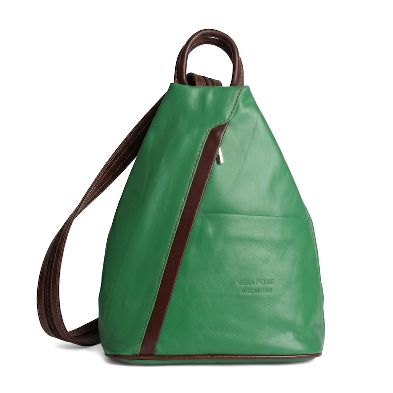 May include: Green leather backpack with brown accents, a top handle, and adjustable shoulder straps. The backpack has a diagonal brown stripe and a small pocket. The text "VERA PELLE MADE IN ITALY" is visible on the front.