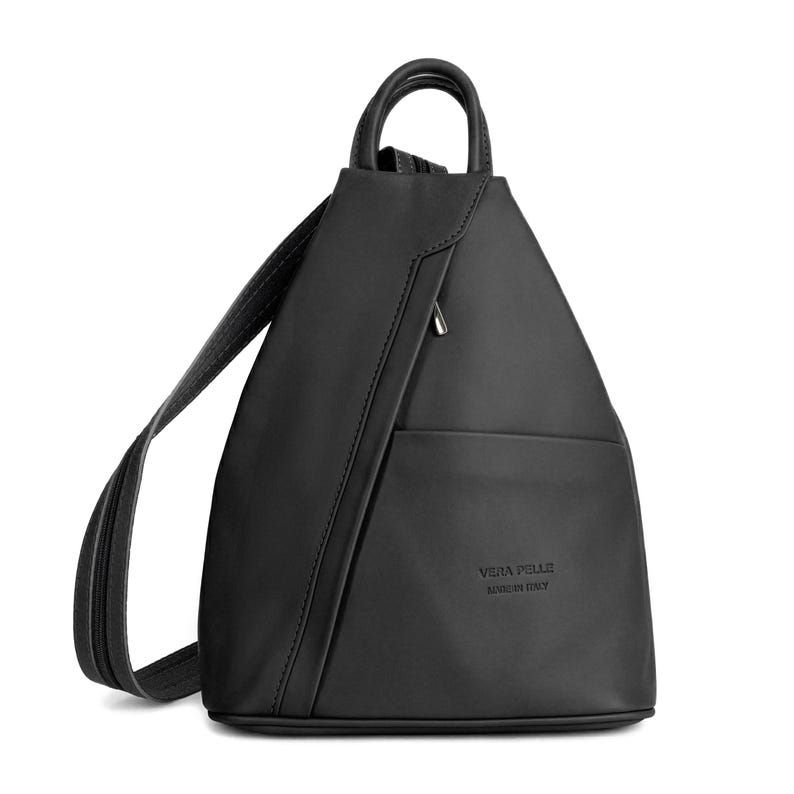 May include: A black leather backpack with a unique triangular shape. The bag features a top handle, adjustable shoulder straps, and a front pocket. The text "VERA PELLE MADE IN ITALY" is embossed on the front. The bag is approximately 12 inches tall.