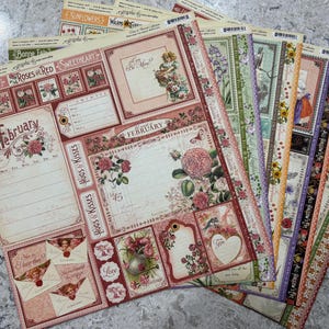May include: A collection of decorative scrapbook paper sheets with floral and vintage designs. The sheets feature roses, hearts, and the word "February". Colors include red, pink, green, and cream.