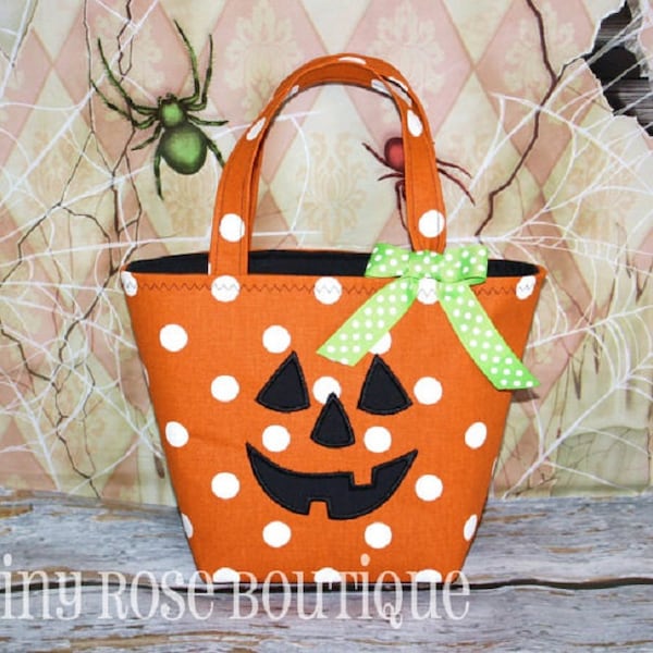 May include: Orange and white polka dot trick or treat bag shaped like a jack-o'-lantern with a green and white polka dot bow.