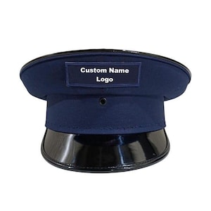 Op de afbeelding: Een marineblauwe hoed met een glanzende zwarte rand. De hoed heeft een rechthoekige patch met de woorden "Custom Name" en "Logo" in witte tekst. Een klassieke hoed.