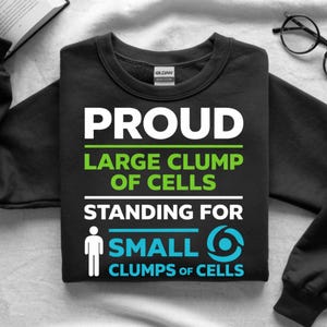 May include: Black sweatshirt with the text "PROUD LARGE CLUMP OF CELLS STANDING FOR SMALL CLUMPS OF CELLS" in white, green, and blue. The sweatshirt has a crew neck and a tag that says "GILDAN".