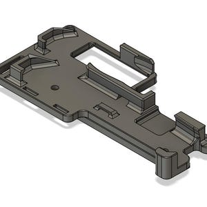 May include: A 3D printed plastic part with a complex design, featuring multiple slots and openings. The part is gray and has a smooth finish.