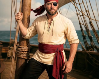 May include: A pirate costume featuring a cream-colored peasant shirt with a lace-up neckline, black pants, and a burgundy sash. The pirate wears a red bandana, an eye patch, and stands on a wooden ship deck.