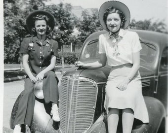 Modern Western Women in Stylish Hats Sitting on Car Fenders in 1941 Montana Photo