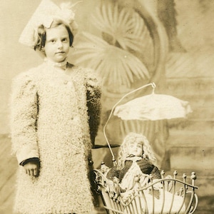 Bambina con la sua BAMBOLA in una CARROZZA per bambole ORNATA - Cartolina fotografica originale degli anni '10