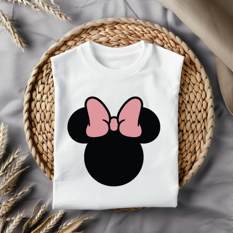 Pu&ograve; includere: Maglietta bianca con una grafica di testa di Minnie Mouse nera e rosa.