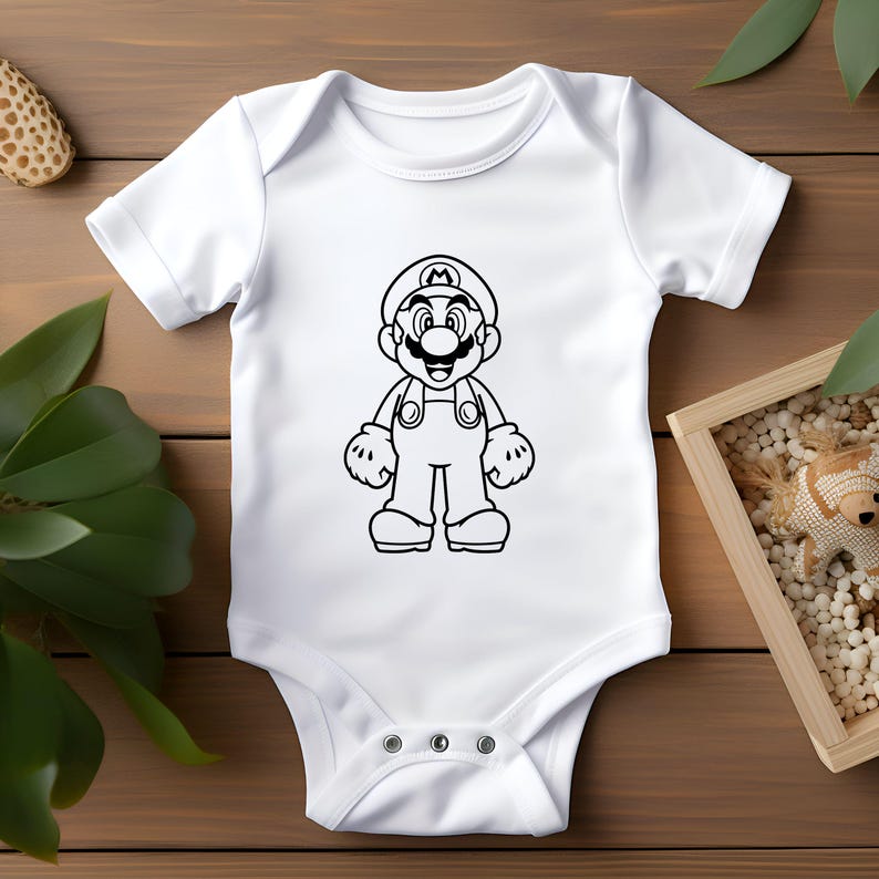 May include: White baby onesie featuring a black outline illustration of the video game character Mario. The design shows Mario in his signature overalls, hat, and gloves. The onesie has short sleeves and snap closures.