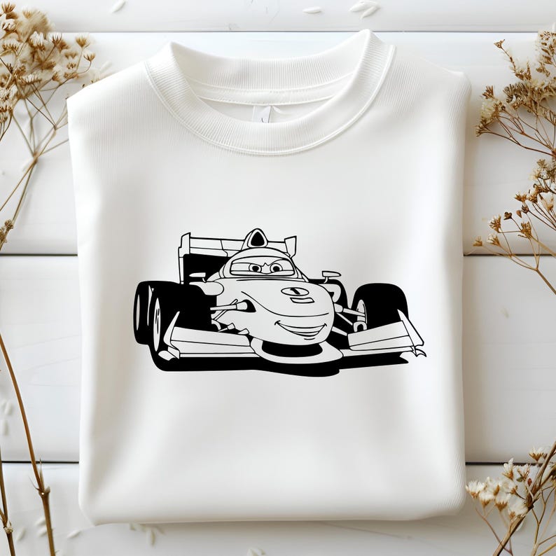 May include: A white sweatshirt featuring a black and white illustration of a cartoon race car driver. The driver is wearing a helmet and goggles and has a big smile. The car is a Formula One race car with a large wing at the back.
