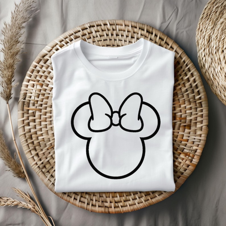 Pu&ograve; includere: Maglietta bianca con un contorno nero della testa e del fiocco di Minnie Mouse.