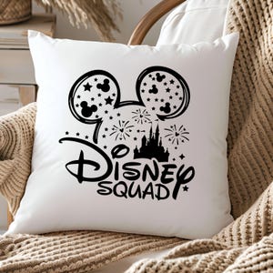 Pu&ograve; includere: Cuscino bianco con una silhouette nera di orecchie di Topolino, un castello, fuochi d'artificio e il testo "Disney Squad".