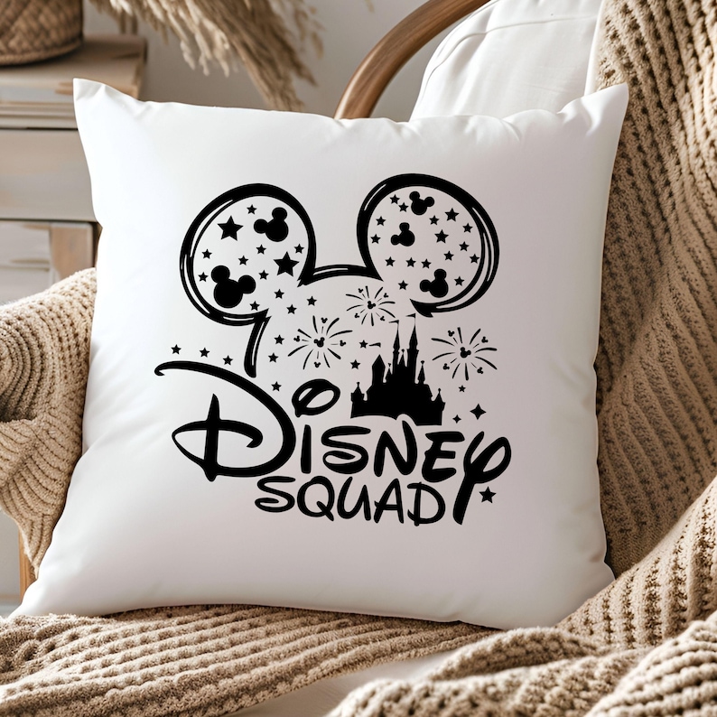 Pu&ograve; includere: Cuscino bianco con una silhouette nera di orecchie di Topolino, un castello, fuochi d'artificio e il testo "Disney Squad".