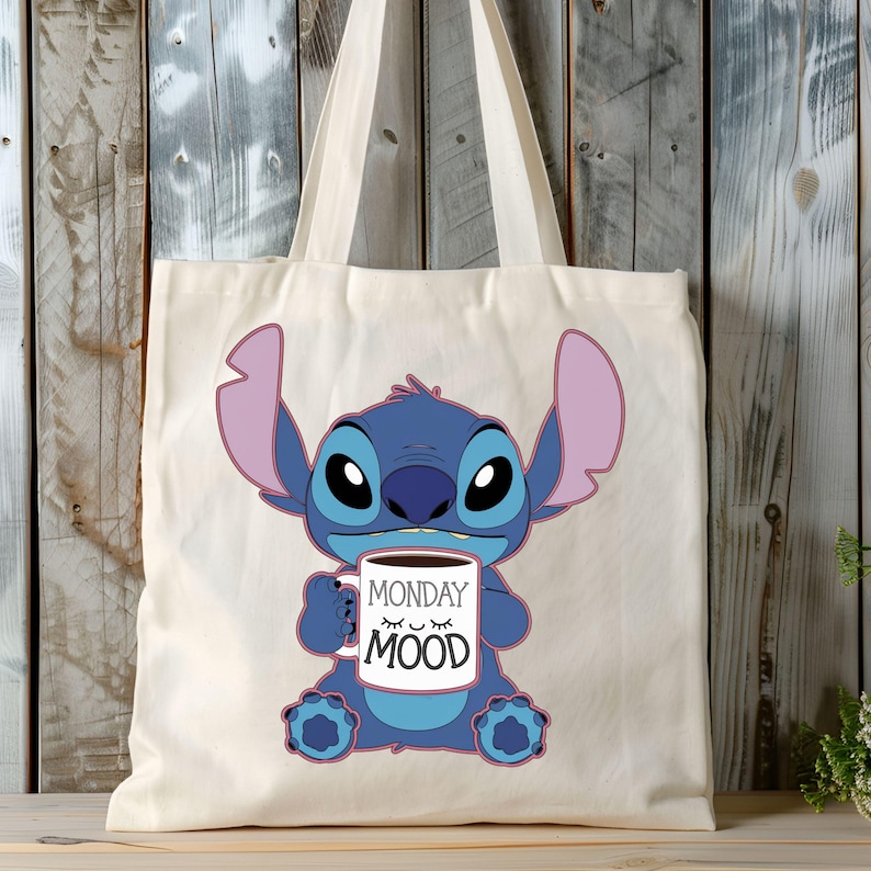 Puede incluir: Una bolsa de tela blanca con un personaje azul Stitch sosteniendo una taza de caf&eacute; que dice "Monday Mood".