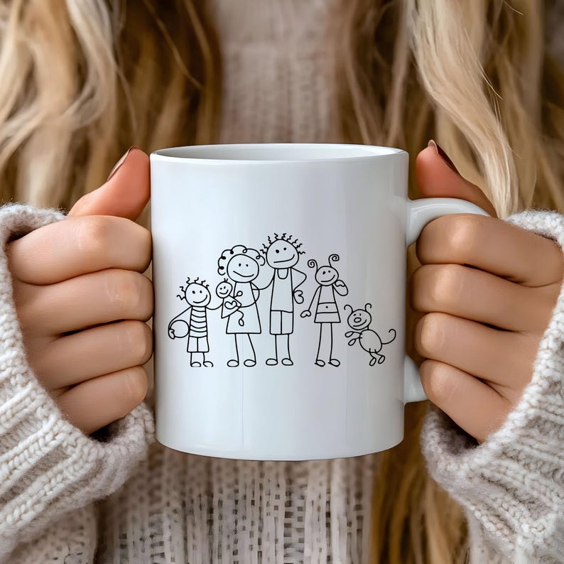 May include: White ceramic mug featuring a black line drawing of a family of six, including a dog. The family members are depicted as stick figures. The mug has a standard handle and is held by a person wearing a light-colored sweater.