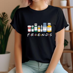 May include: Black t-shirt with a graphic of various medicine bottles and the text "FRIENDS" in colorful letters.