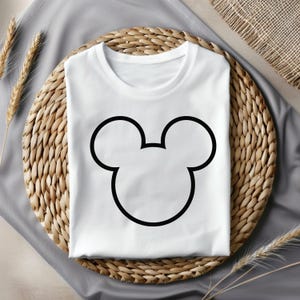 Pu&ograve; includere: Maglietta bianca con un contorno nero delle orecchie di Topolino.