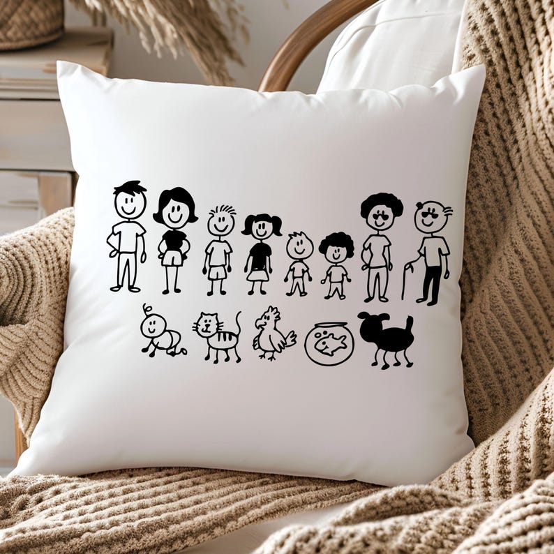 May include: White square throw pillow featuring a black line drawing of a family with children, pets, and grandparents. The pillow is on a white surface, with a neutral-toned blanket and chair in the background.