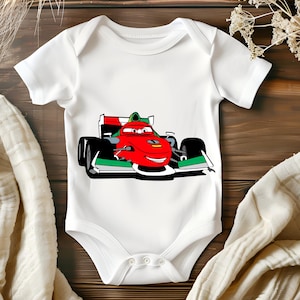 May include: White baby onesie featuring a cartoon image of a red racing car with green and white accents. The car has a smiling face and is driving on a race track.
