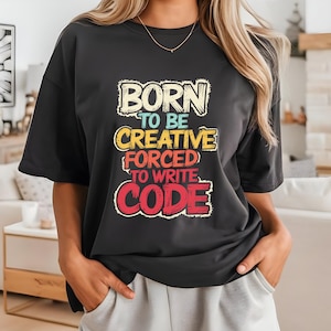 Könnte beinhalten: Schwarzes T-Shirt mit einer bunten Grafik, auf der "Born to be creative forced to write code" steht.