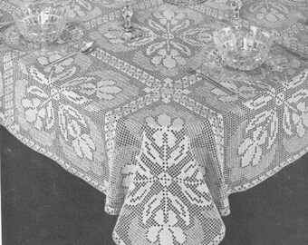 May include: White crocheted tablecloth with a delicate floral pattern. The tablecloth is made with a fine thread and has a delicate, lacy look.