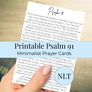 May include: Printable Psalm 91 minimalist prayer cards. The cards feature text from Psalm 91 in a minimalist design. The text is in black on a white background. The cards are held by a person.