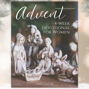 May include: A book cover with the title "Advent" in elegant script. The cover features a nativity scene with figurines of Mary, Joseph, baby Jesus, and a donkey. The text reads "4-Week Devotional for Women" and the author's name, Ann Tatum.
