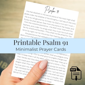 May include: Printable Psalm 91 minimalist prayer cards. The cards feature the text of Psalm 91 in a minimalist design. The image shows a hand holding the cards with a PDF download icon.