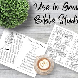 May include: A printed study guide featuring the Armor of God, Fruit of the Spirit, and Divisions of the Bible charts. The text reads Use in Group Bible Studies. A ceramic mug with latte art and a small green topiary plant are also visible.