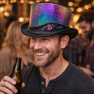 May include: A black top hat with a colourful, iridescent, textured crown. The hat has a black brim and band, with an eye-shaped embellishment. A unique accessory.