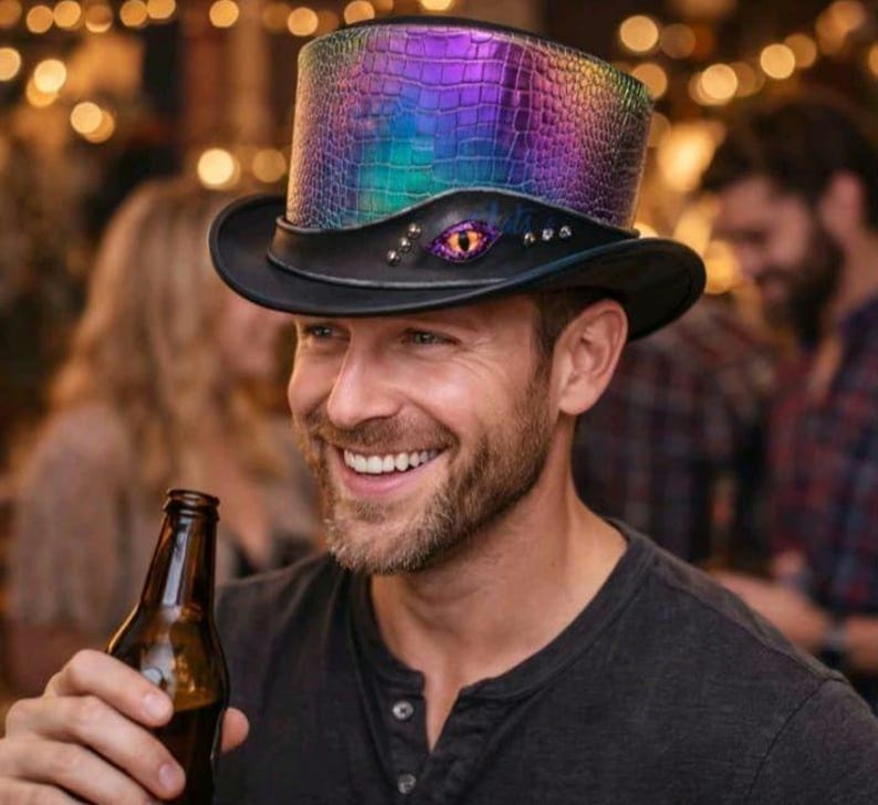 May include: A black top hat with a colourful, iridescent, textured crown. The hat has a black brim and band, with an eye-shaped embellishment. A unique accessory.