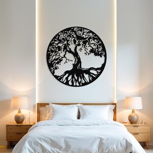 May include: A black metal tree of life wall decor with intricate branches and roots, hanging on a white wall above a white bed with white bedding and two bedside tables with lamps.