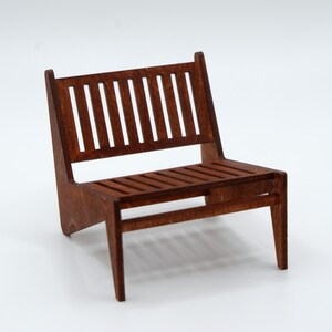 May include: A miniature chair constructed from brown wood, featuring a slatted backrest and a slatted seat. The chair has four legs and a low-profile design with a visible wood grain texture throughout the entire structure of the piece.