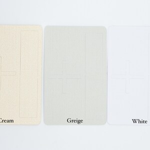 May include: Three rectangular cards with rounded corners, each featuring a debossed plus sign and a vertical rectangle outline. The cards are displayed in cream, greige, and white, with the corresponding color names printed below each card.