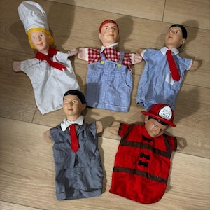 Puede incluir: Cinco marionetas de mano vintage. Las marionetas están vestidas como un chef, un granjero con overoles, un hombre de negocios con traje, un niño con camisa azul y corbata y un bombero. El sombrero del bombero dice "Fire Chief".