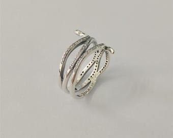 May include: A silver-toned ring with a snake design. The ring features three intertwined bands, with one band adorned with small, clear stones. The ring has a curved, open design and a snake head detail.