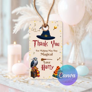 May include: A beige tag with a witch hat, text reading "Thank You For Making May Day Magical Love Harry", and illustrations of an owl, books, and a broom. A string is attached at the top.