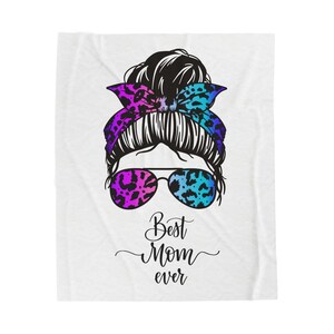 Könnte beinhalten: Weiße Decke mit einer Grafik einer Frau mit einem Dutt, Sonnenbrille und einem Leoparden-Stirnband. Die Sonnenbrille und das Stirnband haben lila und blaue Akzente. Der Text "Best Mom ever" ist darunter geschrieben.