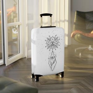 Könnte beinhalten: Ein weißer Rollkoffer mit einem schwarz-weißen Blumen- und Geometriedesign. Das Design umfasst eine große Blume, eine Raute und kleine Punkte. Der Koffer hat einen ausziehbaren Griff und vier schwarze Räder.