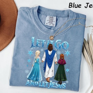 May include: A light blue Comfort Colors t-shirt with the text "LET IT GO AND LET JESUS" and a graphic of Jesus with two characters from the movie Frozen. A gold necklace is draped across the shirt.