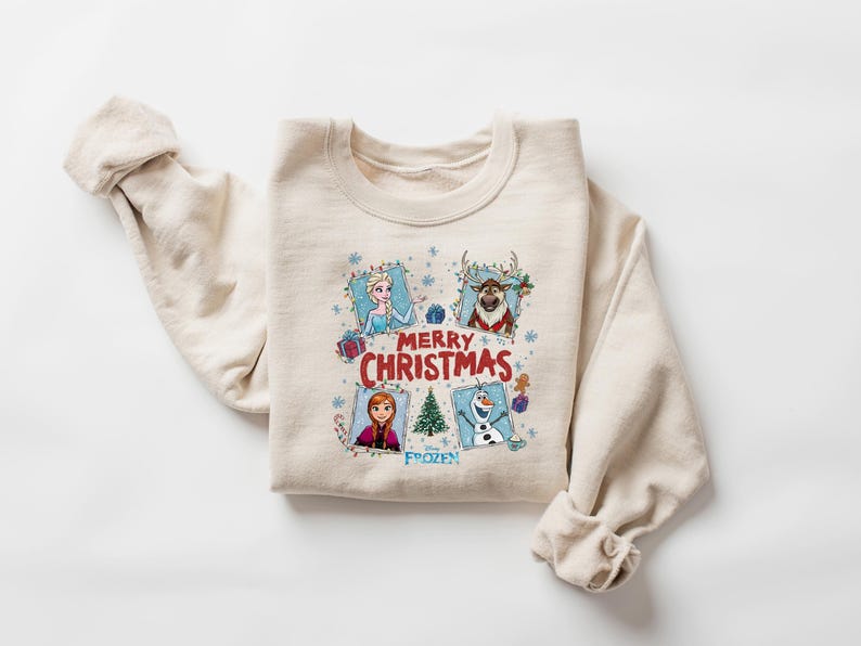 Puede incluir: Sudadera beige de cuello redondo con personajes de la pel&iacute;cula Frozen. El dise&ntilde;o incluye a Elsa, Anna, Olaf y Sven, con las palabras "Merry Christmas" y "Frozen". Una prenda festiva y c&oacute;moda.