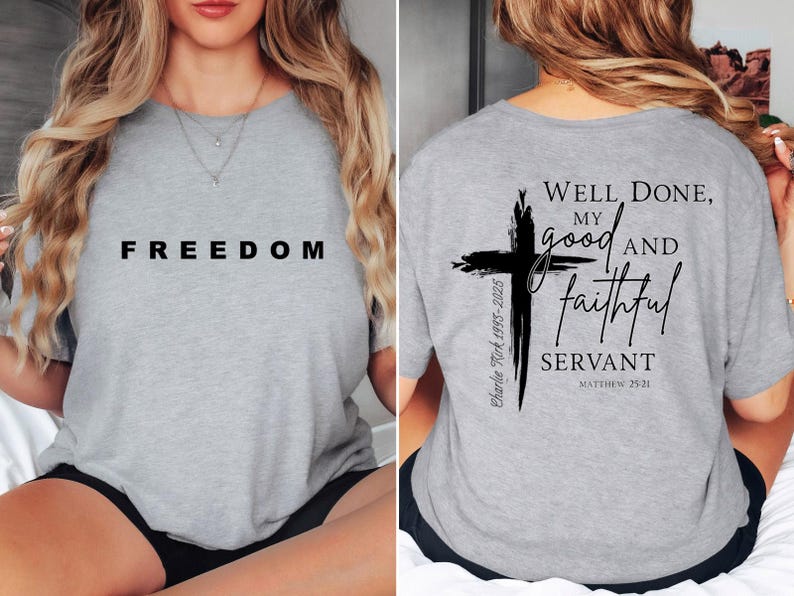 May include: A light grey t-shirt with the word "FREEDOM" printed in black on the front. The back of the shirt features a black cross design with the text "Well Done, my good and faithful servant" and the Bible verse Matthew 25:21.