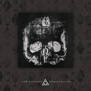 May include: Black and white iron-on patch featuring a distressed skull design. The patch is rectangular and has a black background with a white skull image. The skull has a distressed, vintage look with a textured surface.