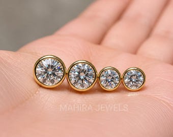 May include: Four round, brilliant-cut clear stones set in polished yellow gold bezels, arranged in a row from largest to smallest. The stones exhibit high clarity and sparkle. The text MAHIRA JEWELS is visible in light gray below the jewelry.