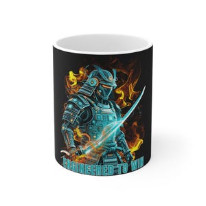 May include: A black ceramic mug featuring a graphic of a futuristic samurai in blue and teal robotic armor, surrounded by orange and yellow flames. The samurai holds a glowing sword, and the text "ENGINEERED TO WIN" is printed in teal at the base.