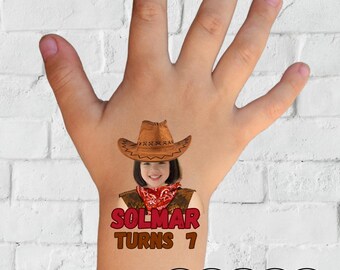 May include: A temporary tattoo design showing a girl in a cowboy hat and bandana. The text "SOLMAR TURNS 1" is in red, with the word "TATTOO" in a pink cloud-shaped frame.
