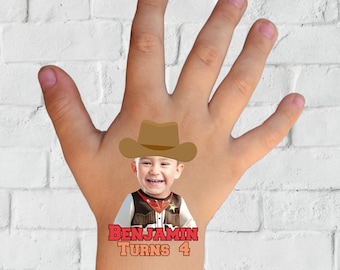 May include: A temporary tattoo featuring a child's face wearing a cowboy hat and a waistcoat. The text "BENJAMIN TURNS 4" is printed below the image. The word "TATTOO" is printed in a pink cloud shape.