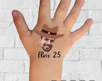 May include: A temporary tattoo featuring a cartoon image of a man wearing a cowboy hat. The text "Elvis 25" is below the image. The word "TATTOO" is written in a pink cloud.